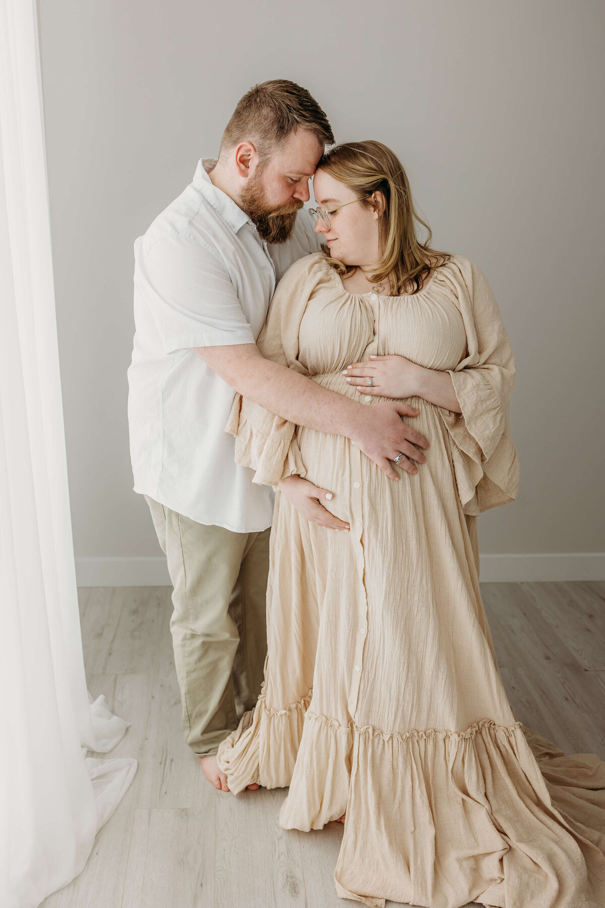 Couple in photography studio near Eau Claire expecting baby