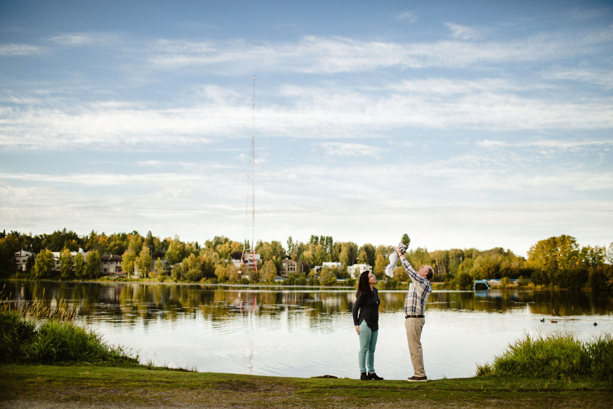 family at westchester lagoon holds baby in the air