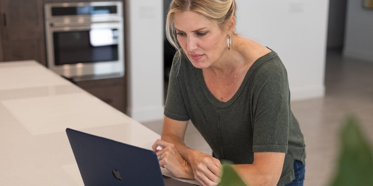 Accountant at home working on her laptop from the kitchen counter