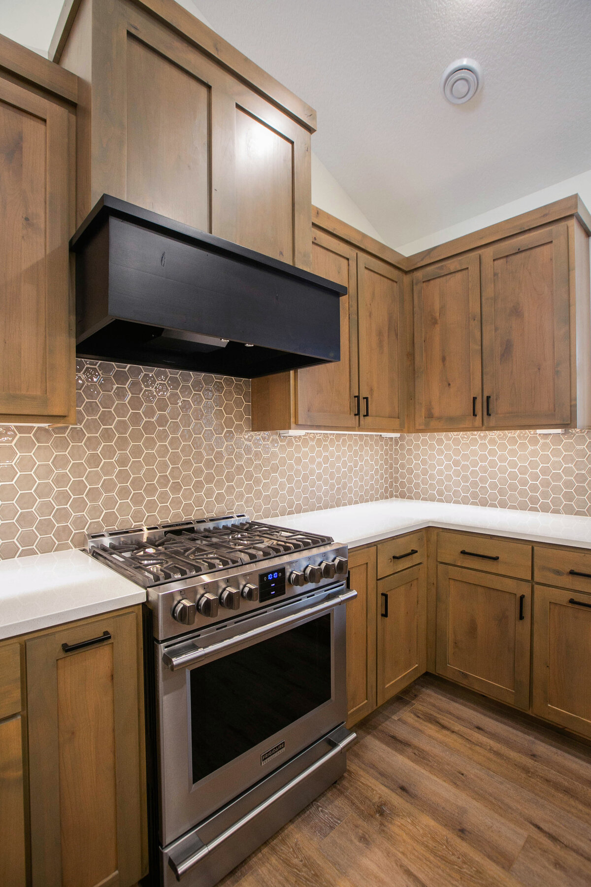 Open kitchen with dark cabinets, large island, and quartz countertops in an Elk River custom home