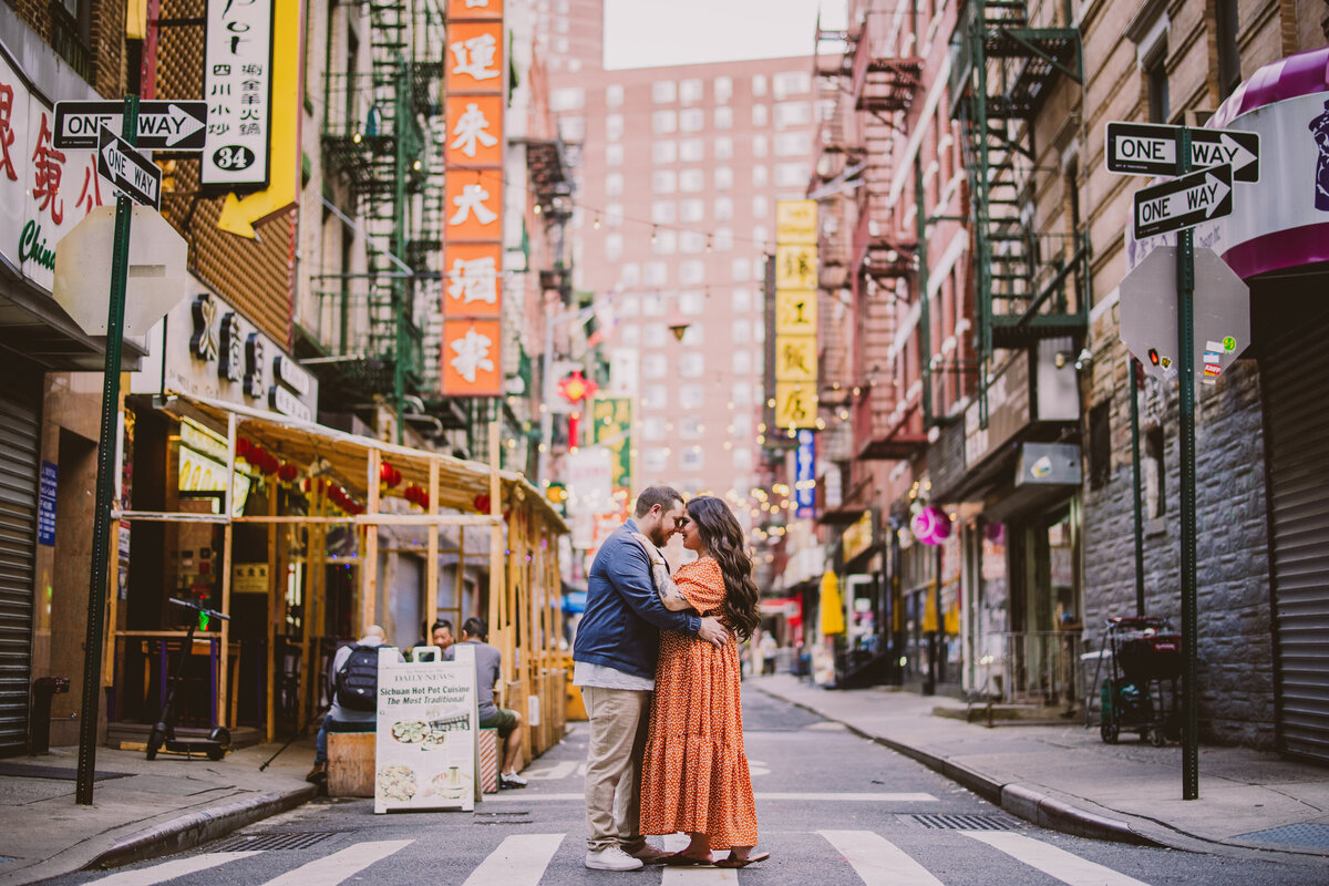 A couple embracing on the street in chinatown nyc during their engagement session
