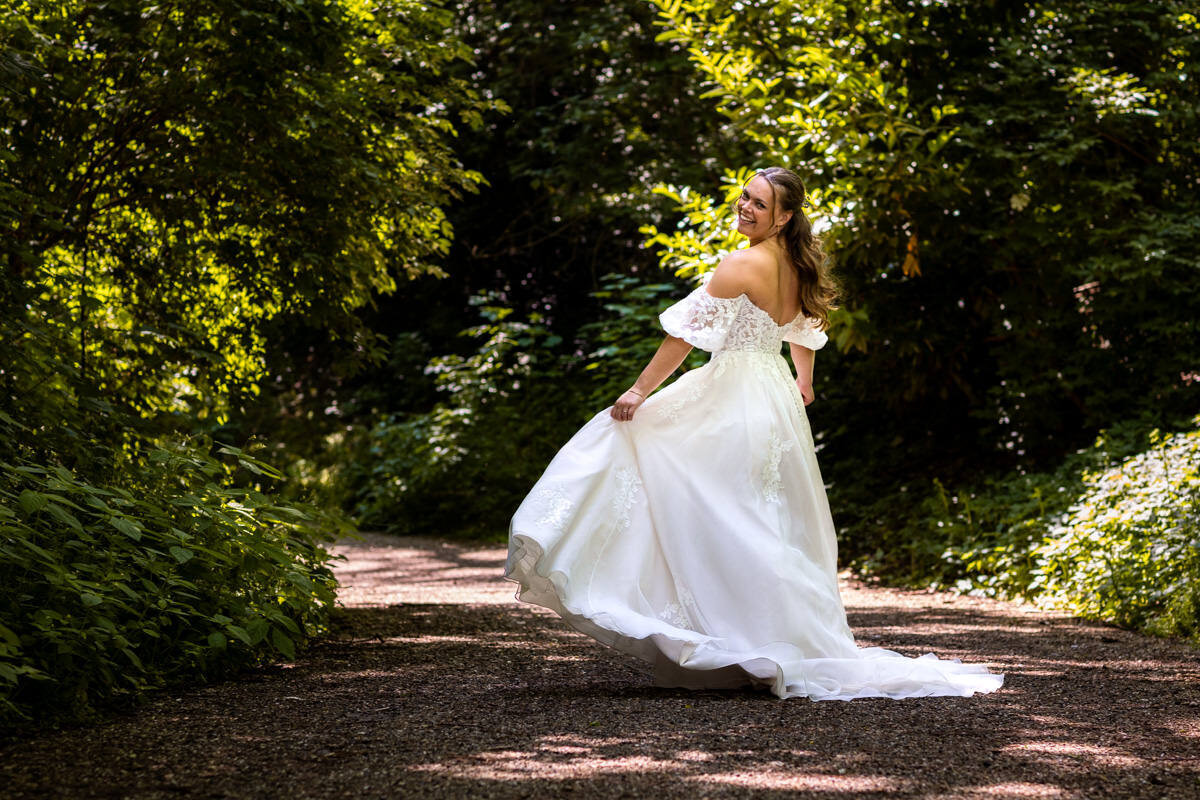 bruid rondzwierend in mooie jurk in groen park