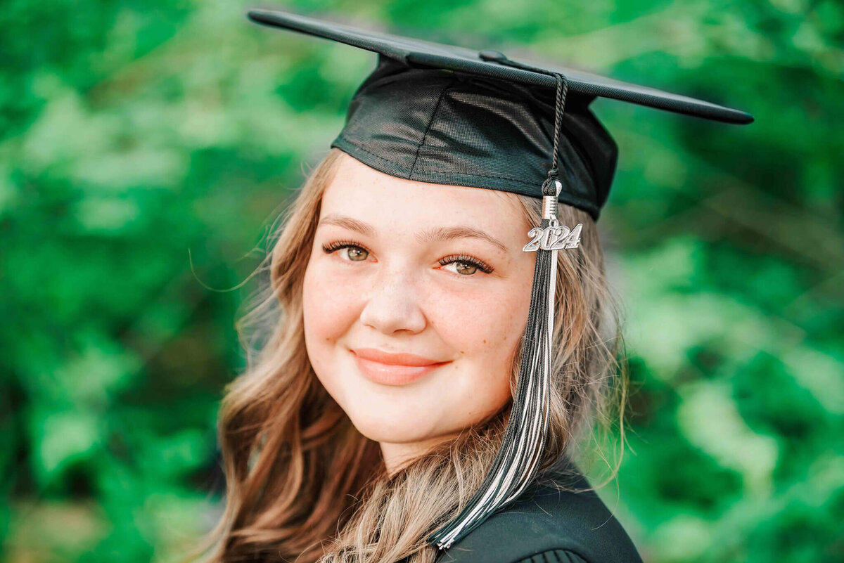 Close up of a pretty brunette girl wearing a grad cap.