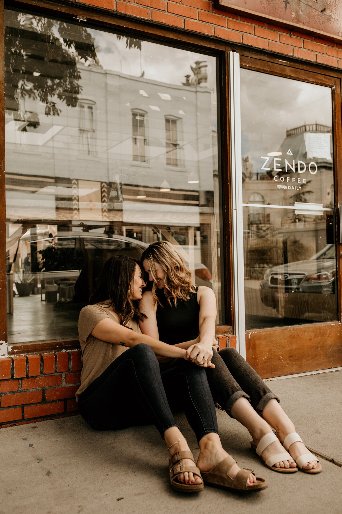 lesbian couple sitting together outside of a coffee shop