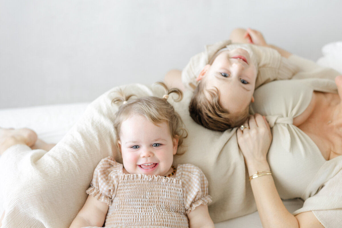 Classic studio maternity portrait of Katie and children laughing, captured in natural light in Tampa