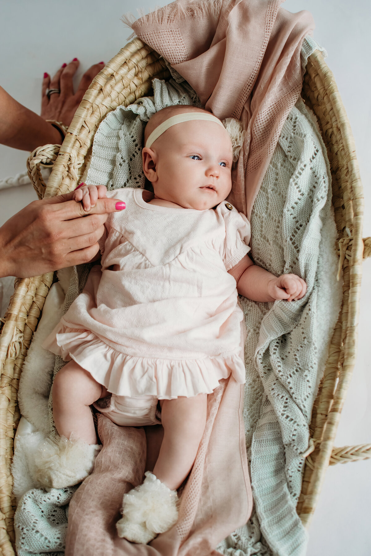 Newborn in a moses basket in photography studio in Bartlett, IL