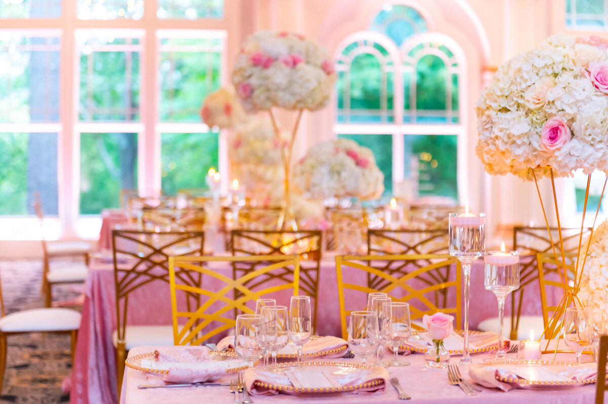 tables decorated with pink cloths and gold chairs