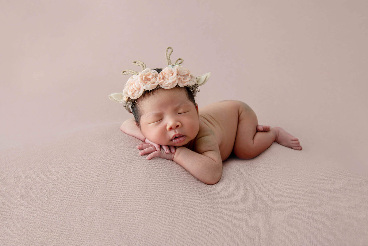 Chinese newborn baby girl on a pink background for her Burlington, Ontario newborn photography session.