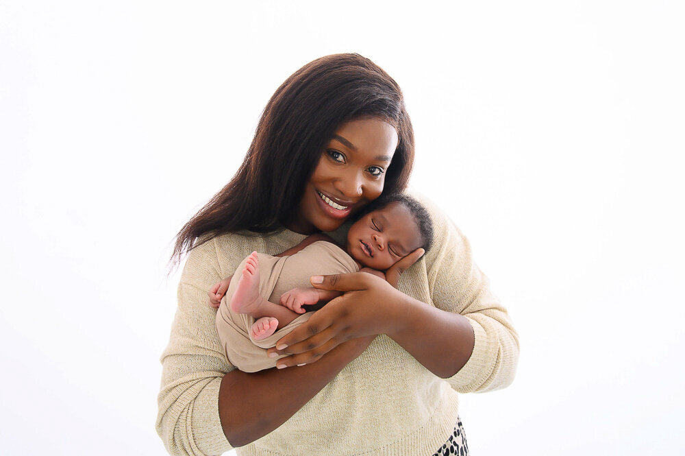 Newborn baby boy being held by his mom for their photos.