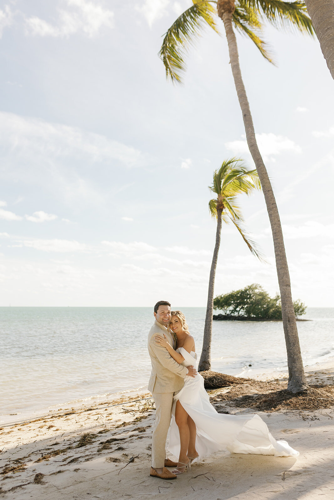 The couple shares an intimate hug on the sandy shores of their destination wedding in the Florida Keys.