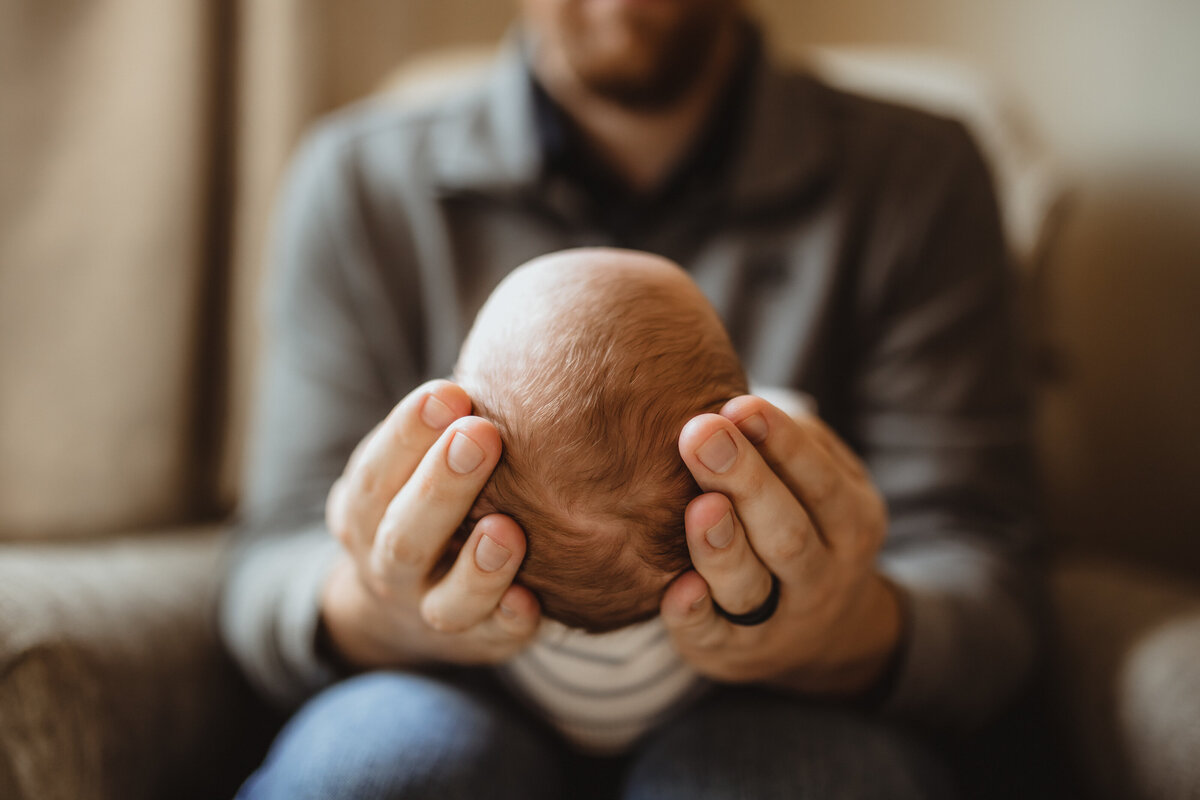 DAD HOLDING BABYS HEAD