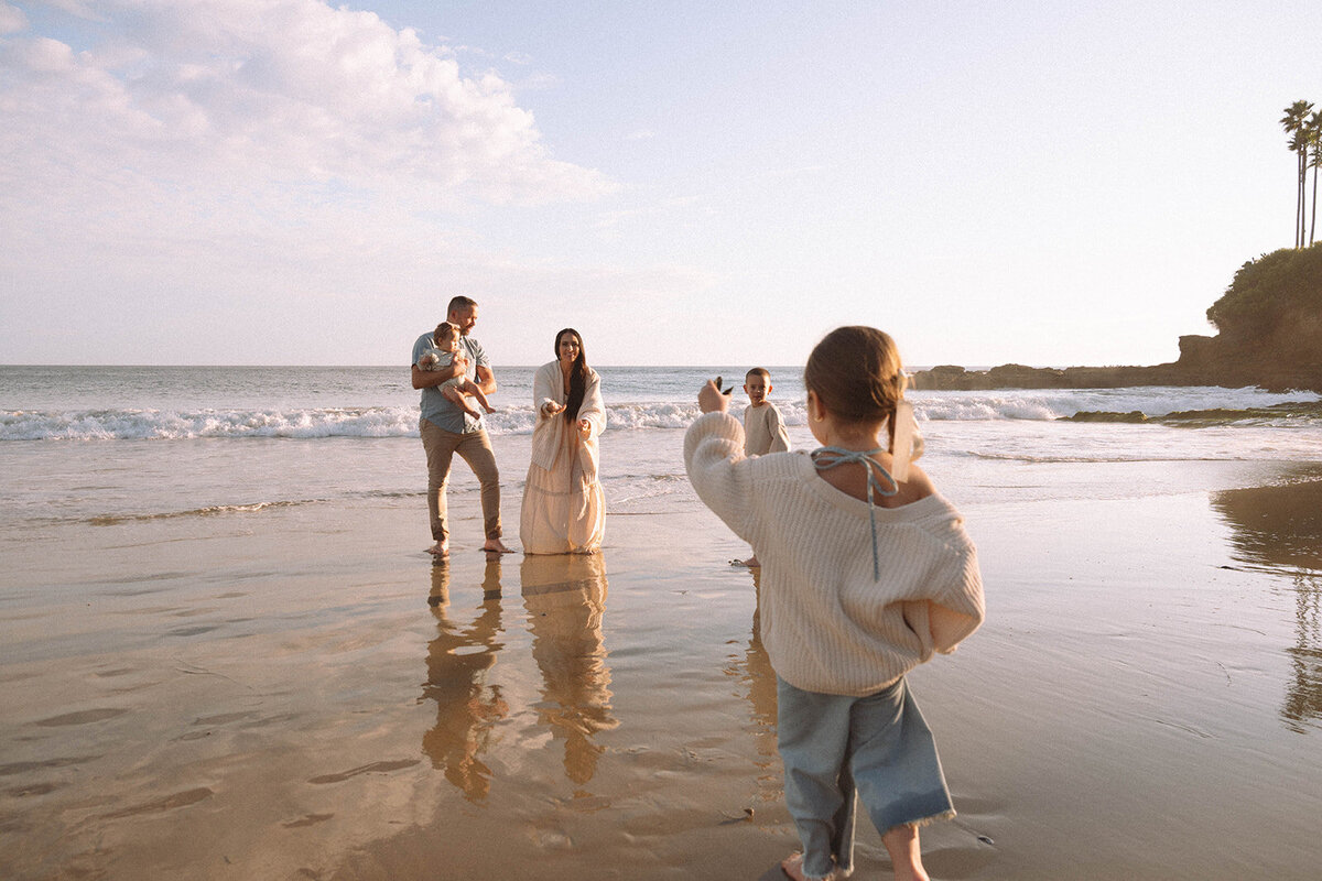 Family of five playing together along the shore at Shaw’s Cove in Laguna Beach during golden hour, captured by Orange County family photographer Maria Alcantara.