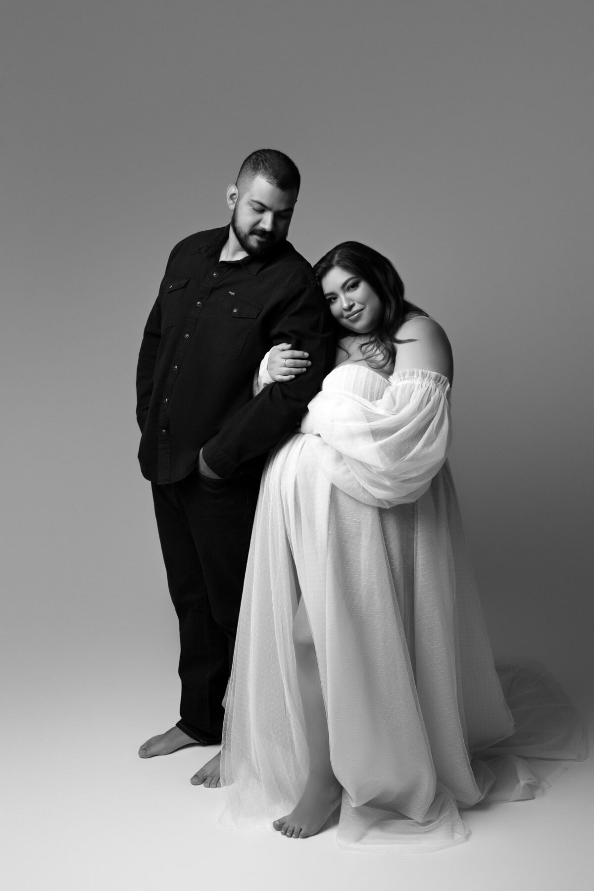 Elegant maternity couple portrait in formal attire during professional photography session