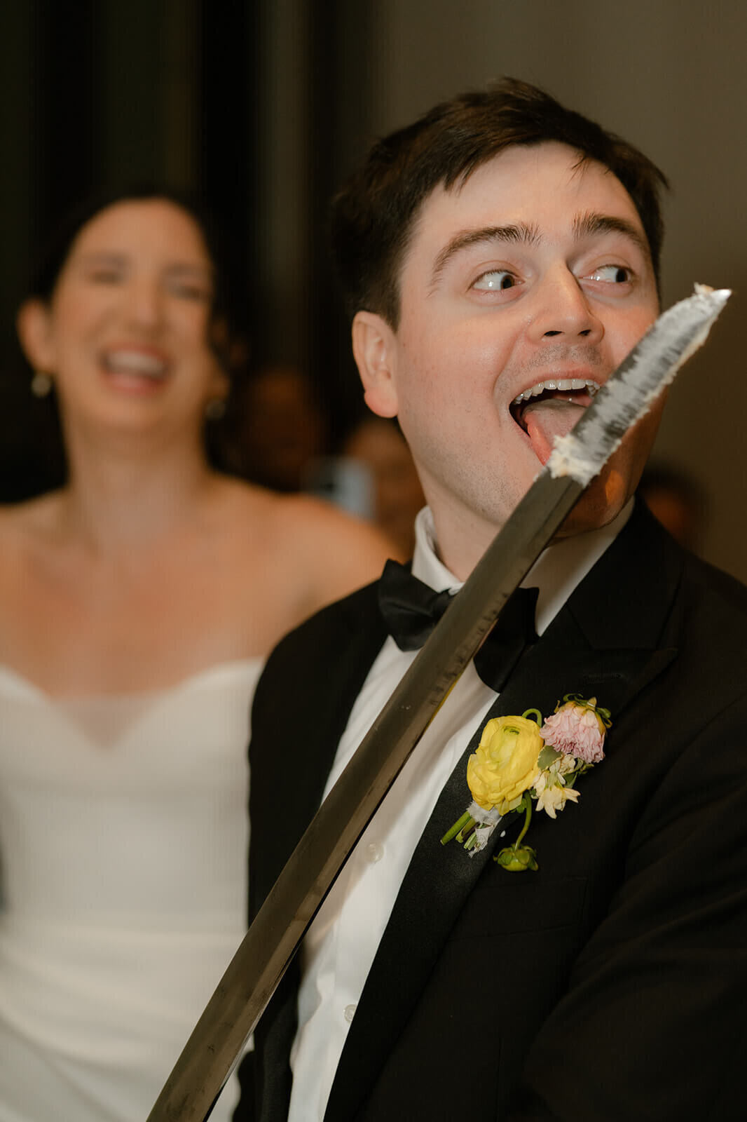 after cutting the cake with a saber, the groom licks the cake