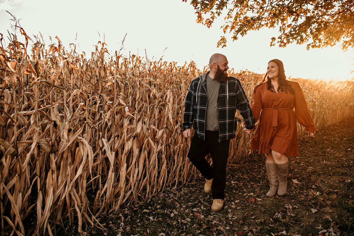 Man and woman walk beside corn field