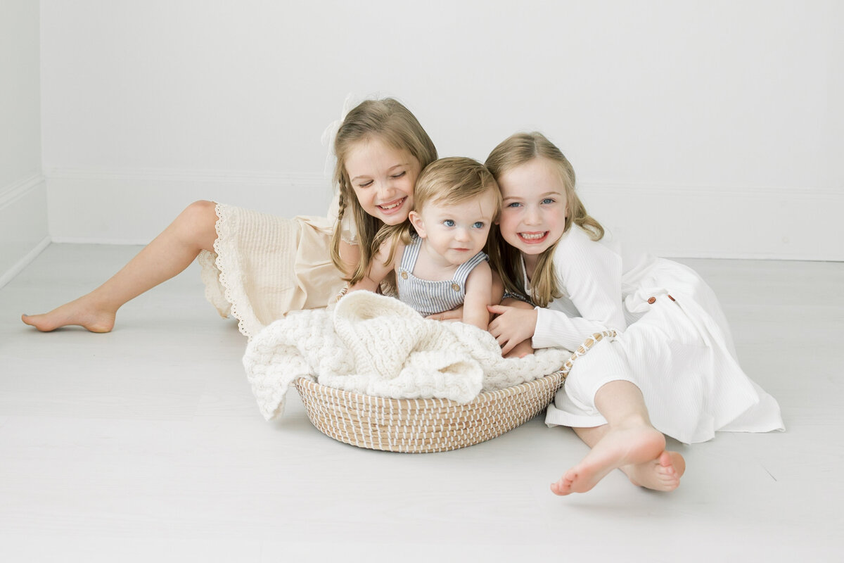 two girls hugging their younger brother