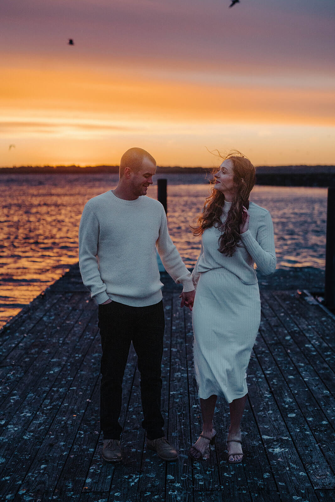Couple standing by lake at Finger Lakes engagement session