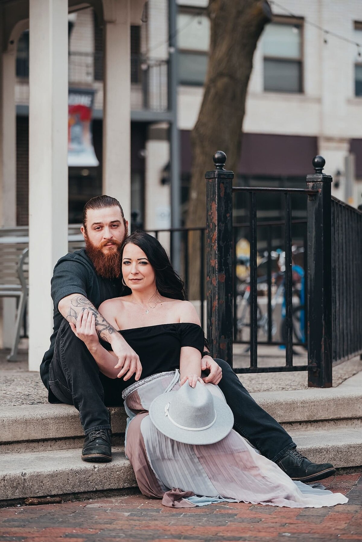 couple sitting outside holding a hat