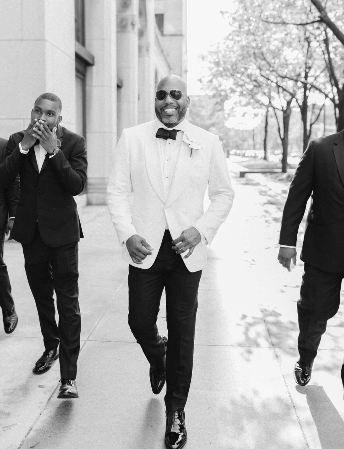 handsome groom with sunglasses, white jacket with groomsmen in Detroit