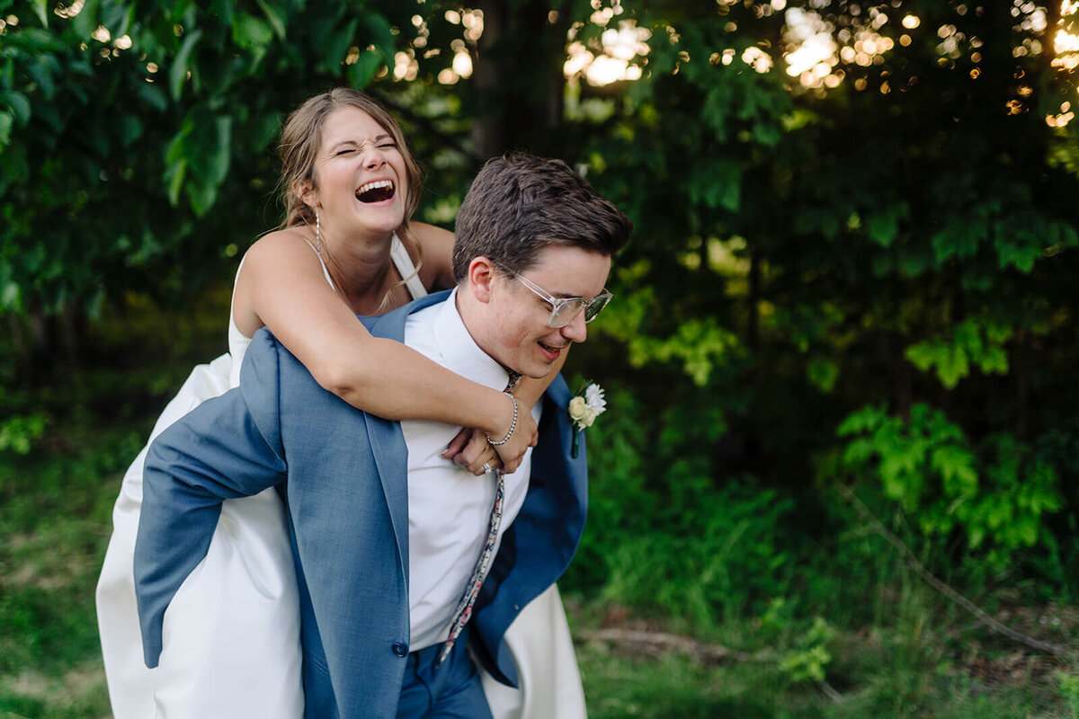 Groom giving bride a piggie back at Oswego wedding, NY