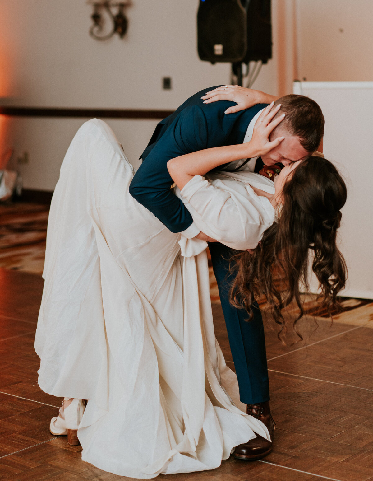 Bride and groom do a dip during their first dance on their wedding day.