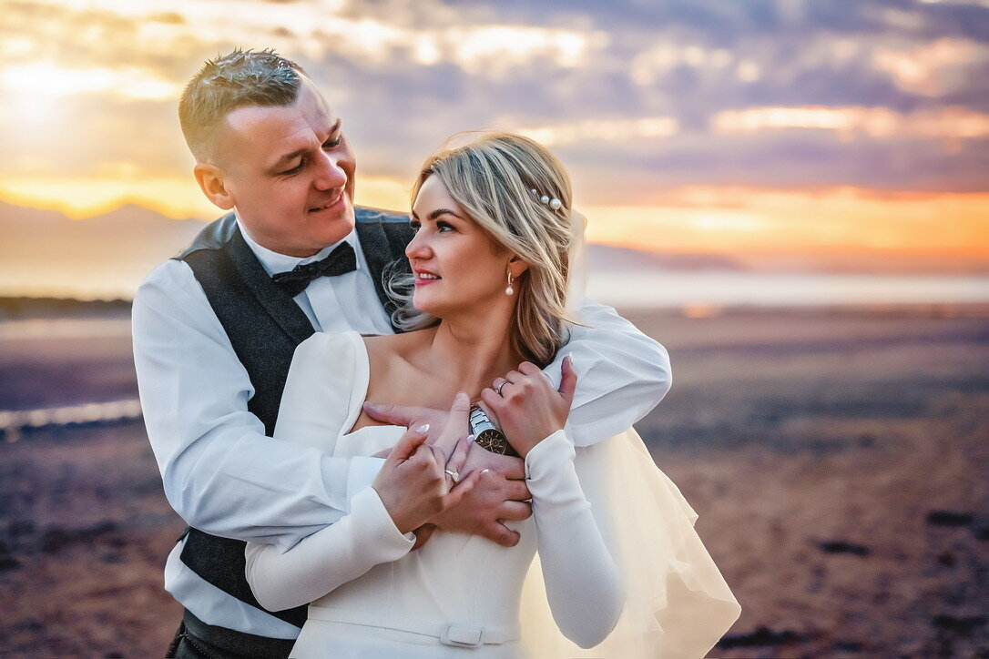 Bride and groom on beach at sunwet