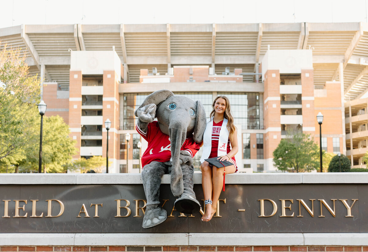Big AL and a graduate sitting on the sign at Bryant Denny Stadium