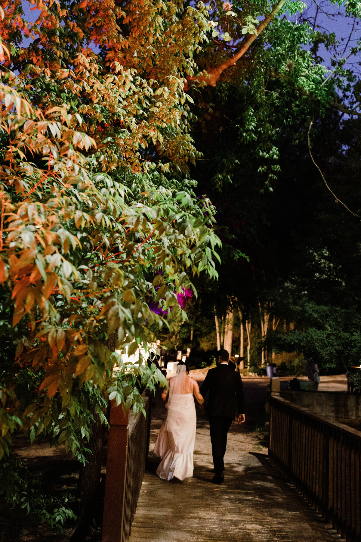 Bride and groom walking along pathway at Umlauf Sculpture Garden, Austin