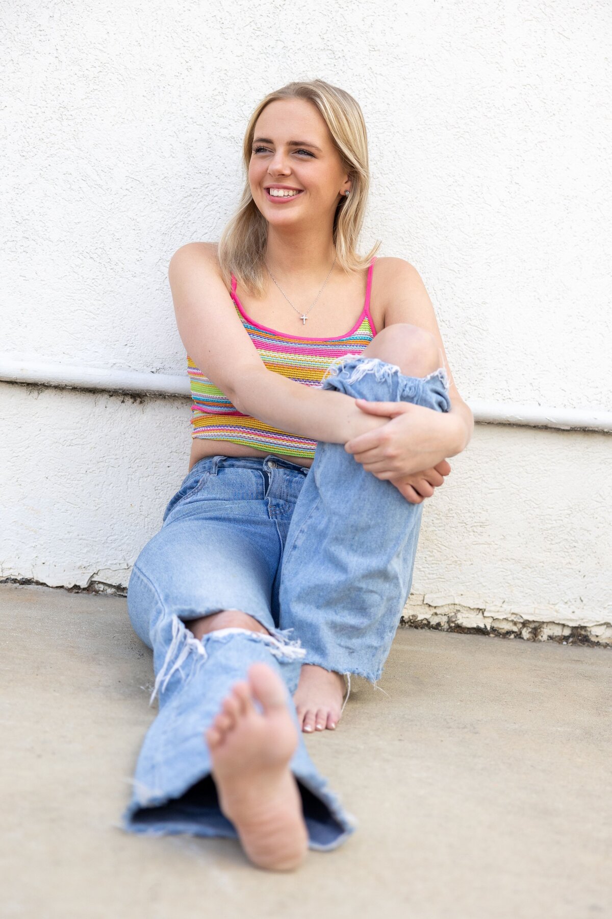senior girl laughing while sitting on ground