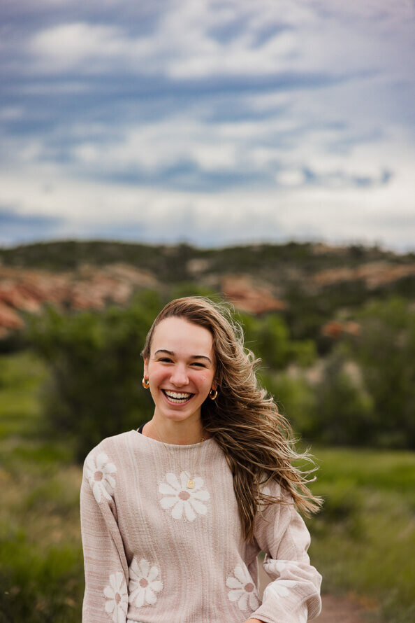Girl smiles for camera during her senior photos.