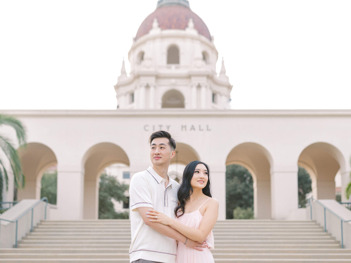 couple standing in front of the steps at pasadena city hall