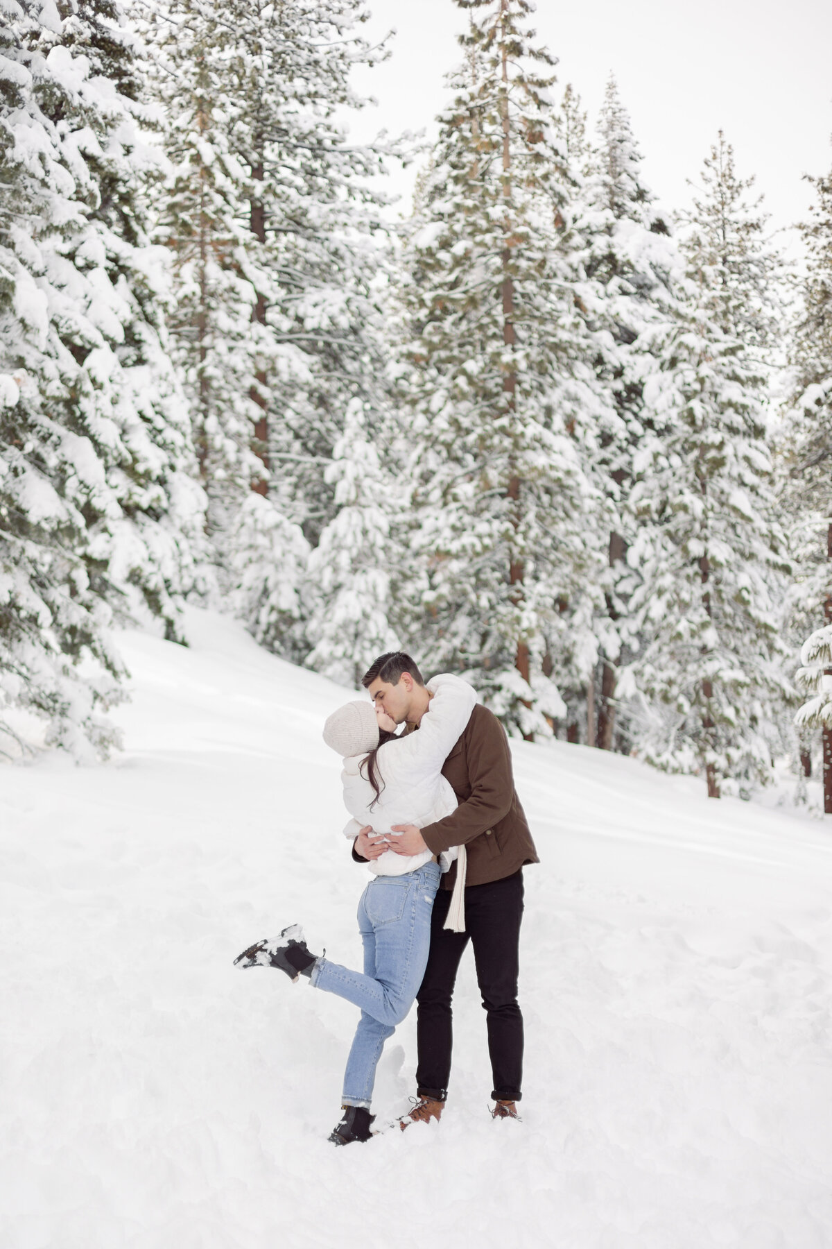 man and woman embracing in a snowy forest