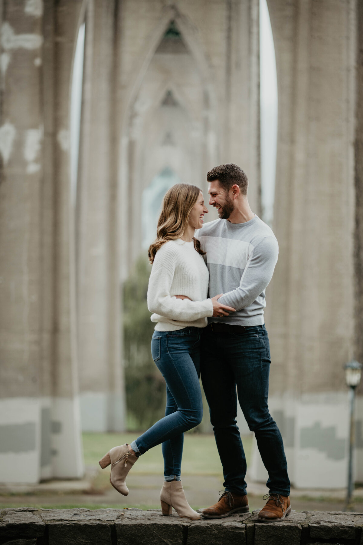 Couple snuggling up close at Cathedral Park in Portland during engagement photos