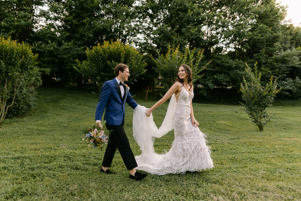 Wedding Photographer, a bride leads her groom through the grass