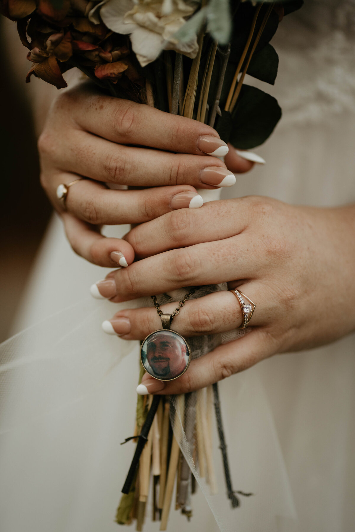 Bride holding bouquet with trinket of loved one