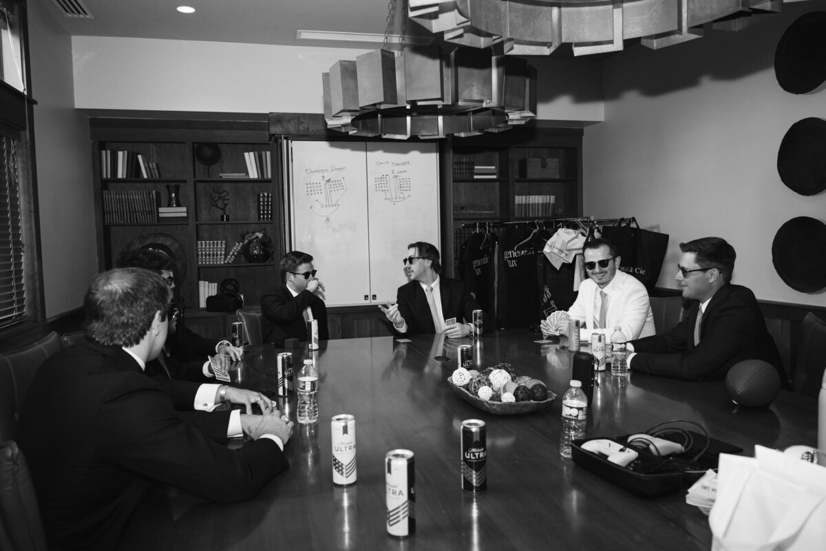 groom and groomsmen playing cards before wedding