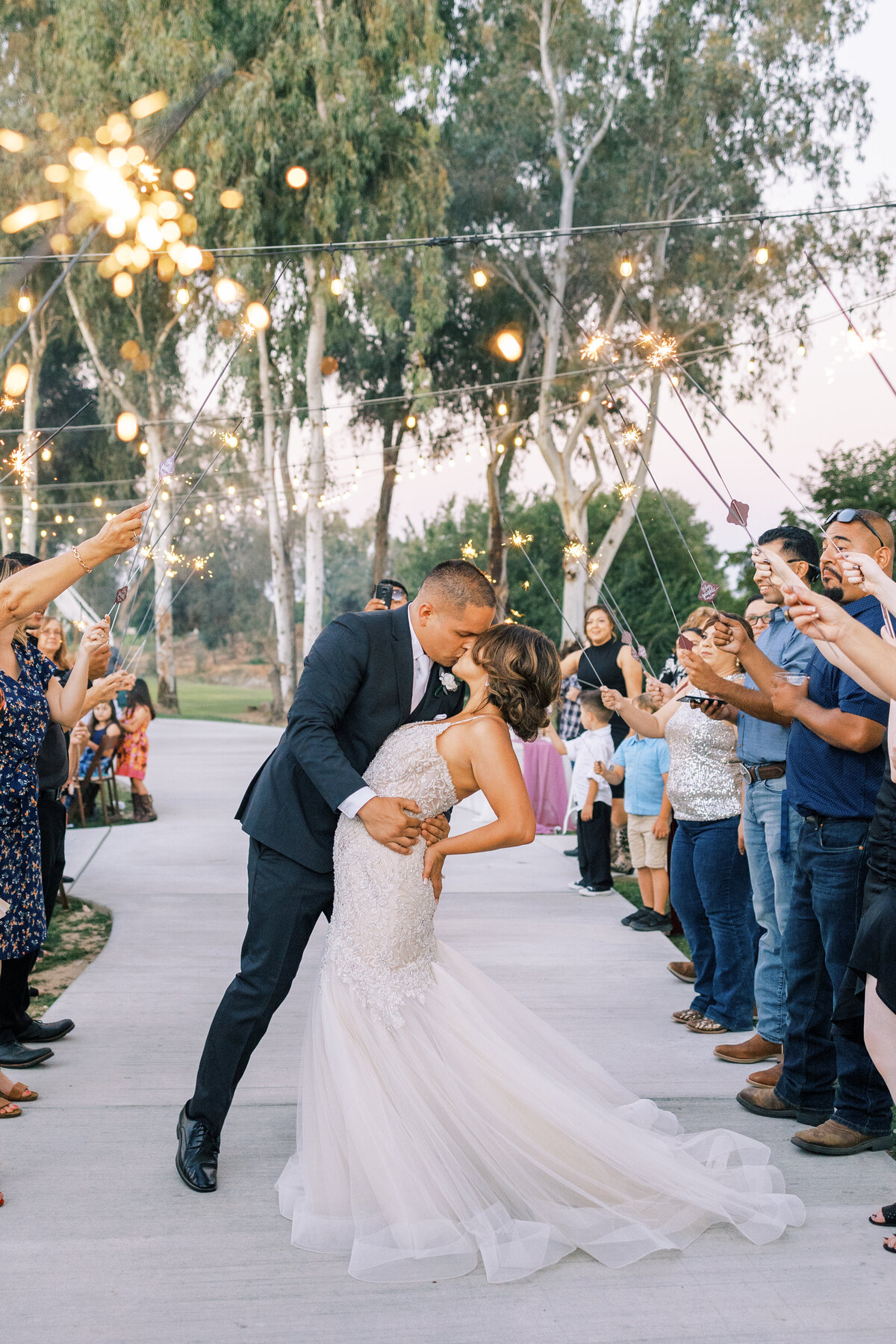 bride and groom kissing during sparkler exit photos