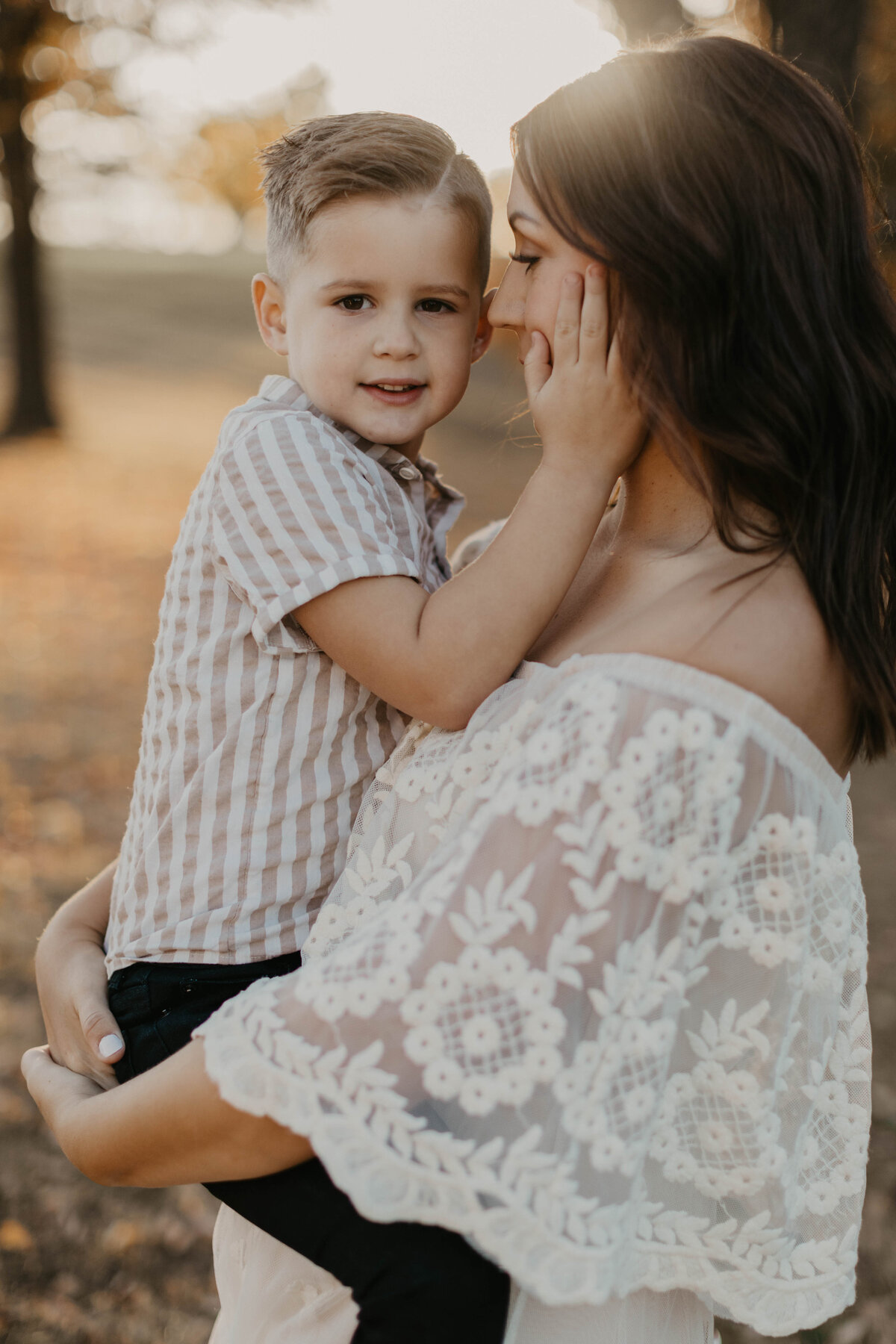 Youngest son holding mom's cheeks.