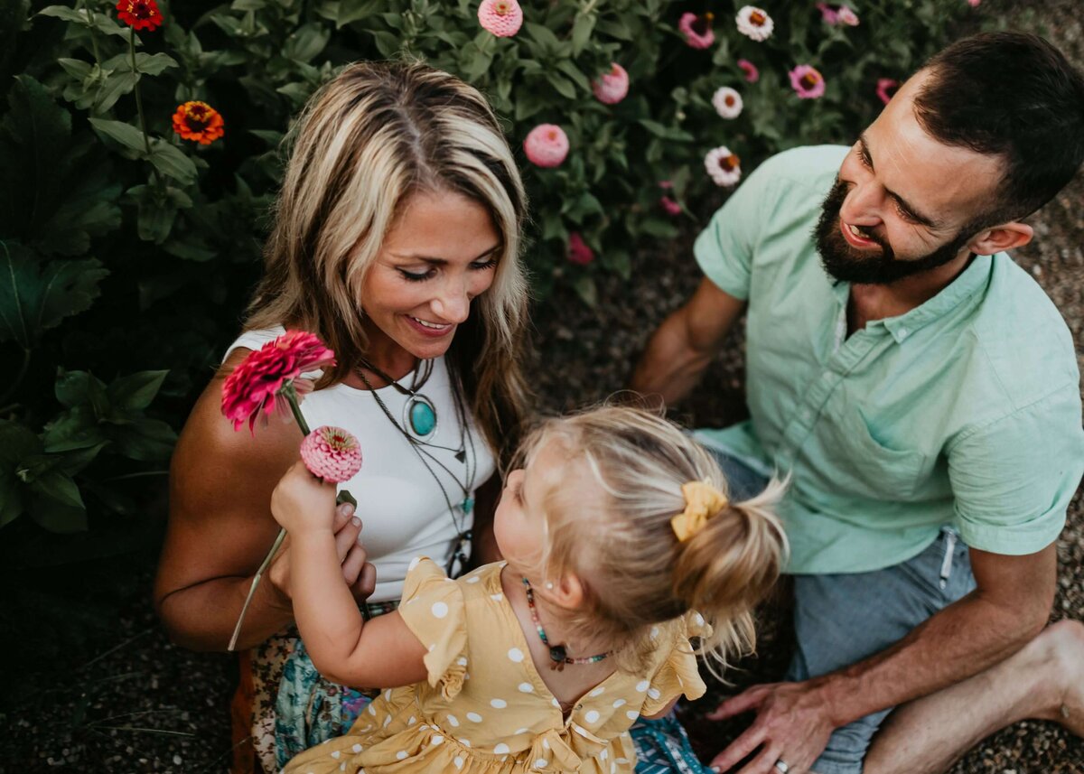Capture a lovely moment with a couple and their daughter in a beautiful garden, by Pittsburgh family photographer.
