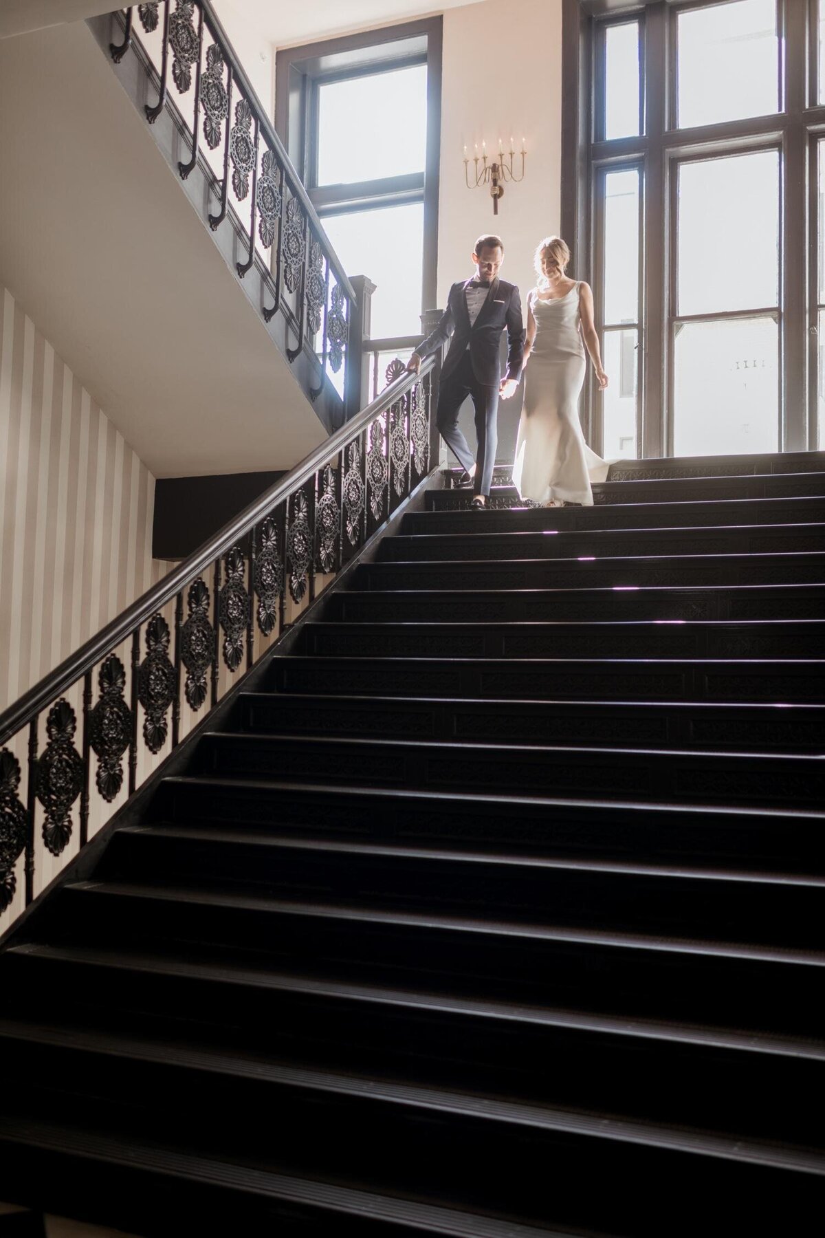 Bride-and-Groom-Walking-down-stair-case-maison-de-la-luz-hotel-New-Orleans.jpg