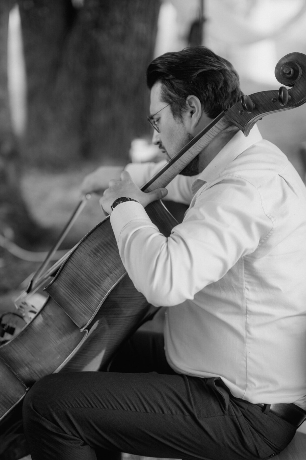 Ein Cellist spielt sitzend auf seinem Instrument.
