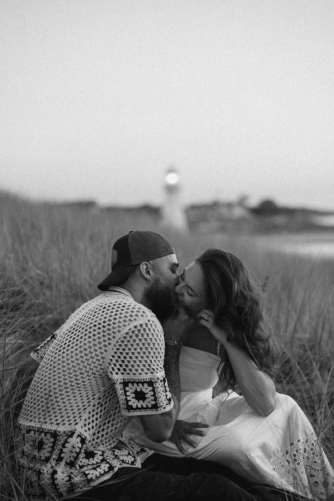 Black and white engagement photo of couple kissing in the dunes at New Buffalo Beach in Michigan