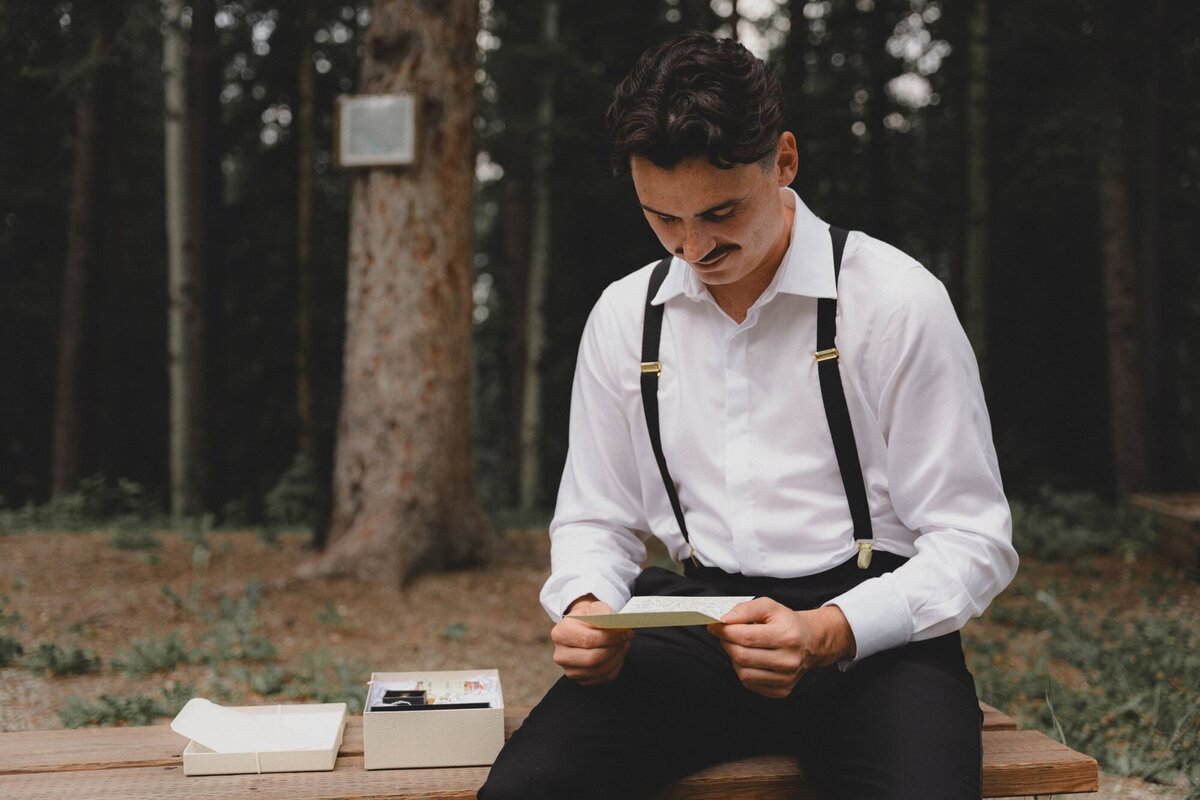 Groom holding love note at Camp Horizon near Calgary Alberta