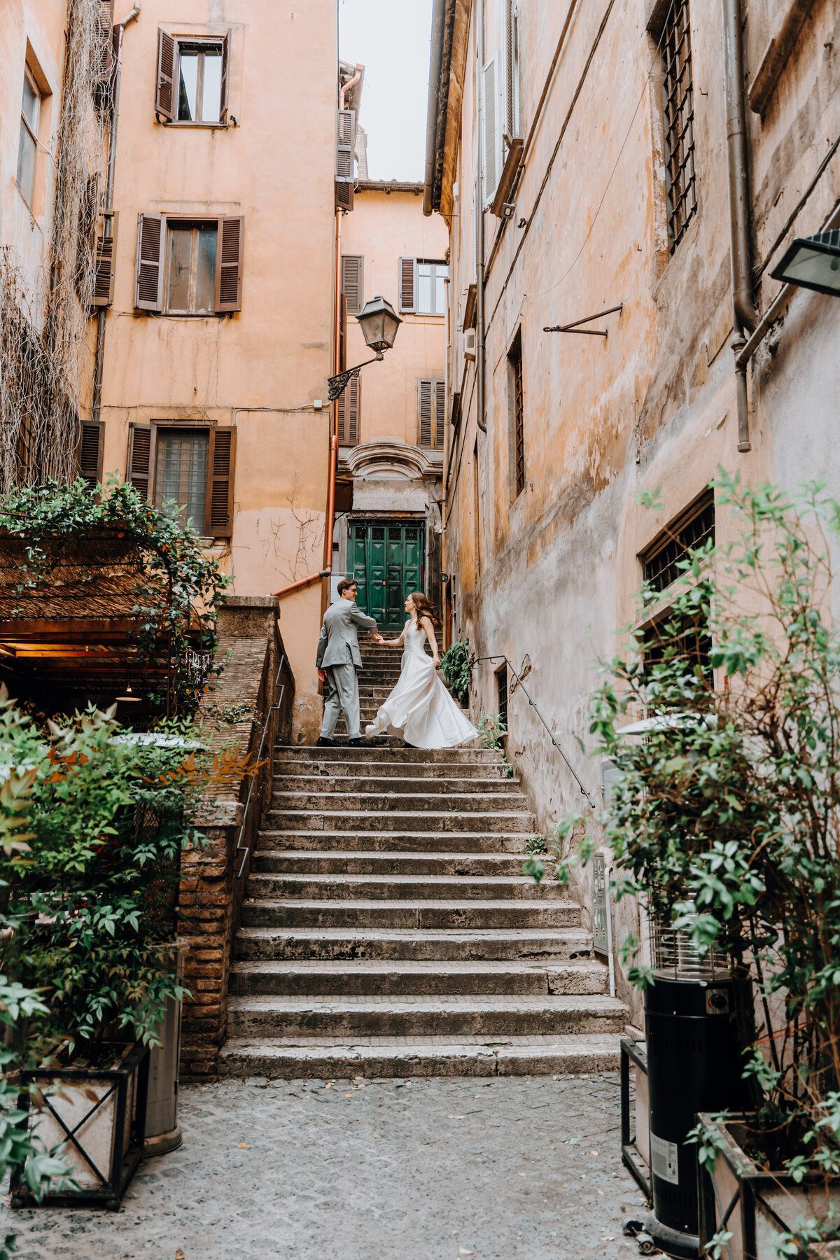Couple dancing through cobblestone alley in Rome.