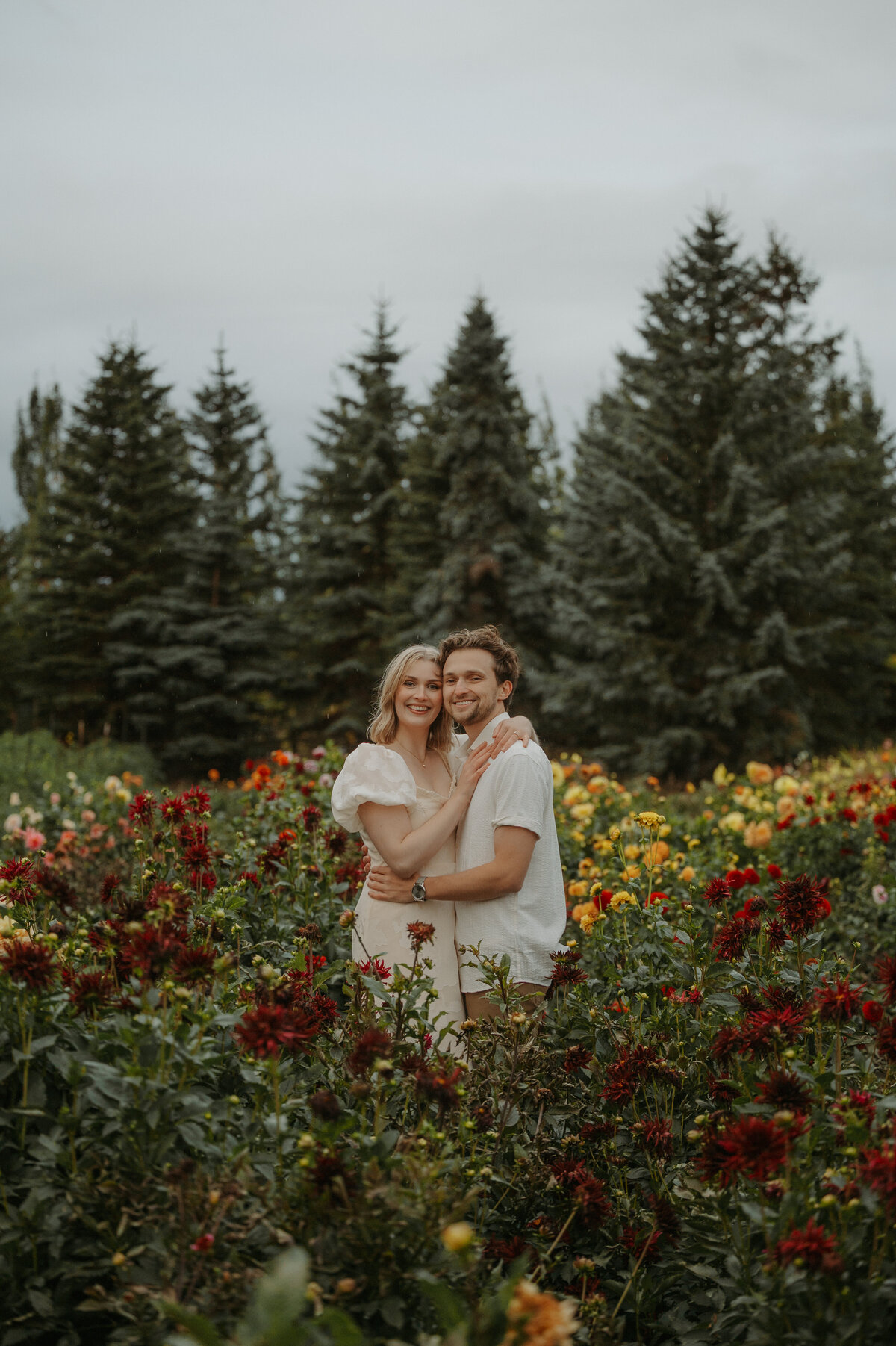 Photography of a couple smiling  in a field full of flowers