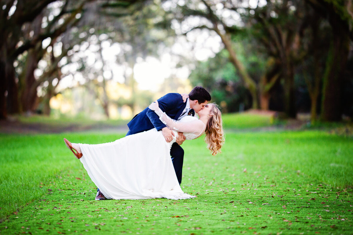 Bride and groom kiss and dip at Legare Waring House Charleston Wedding Photographer