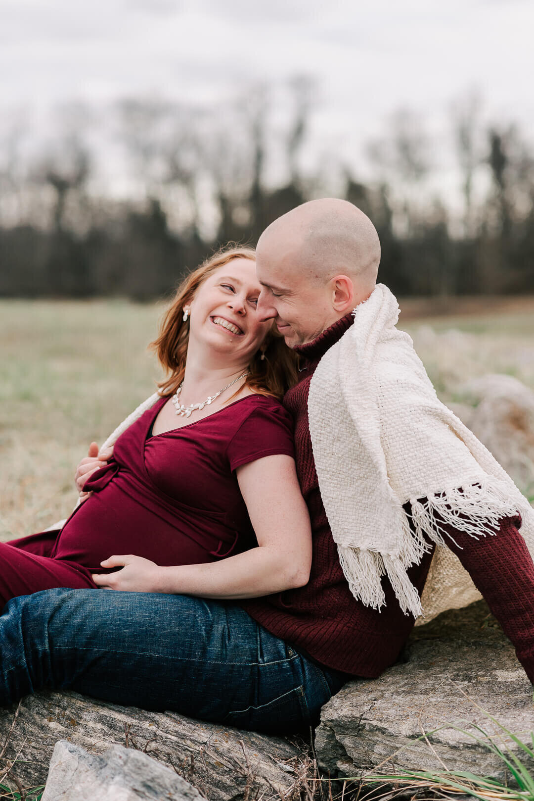 An expecting mom smiling happily at her partner, taken by a northern virginia maternity photographer