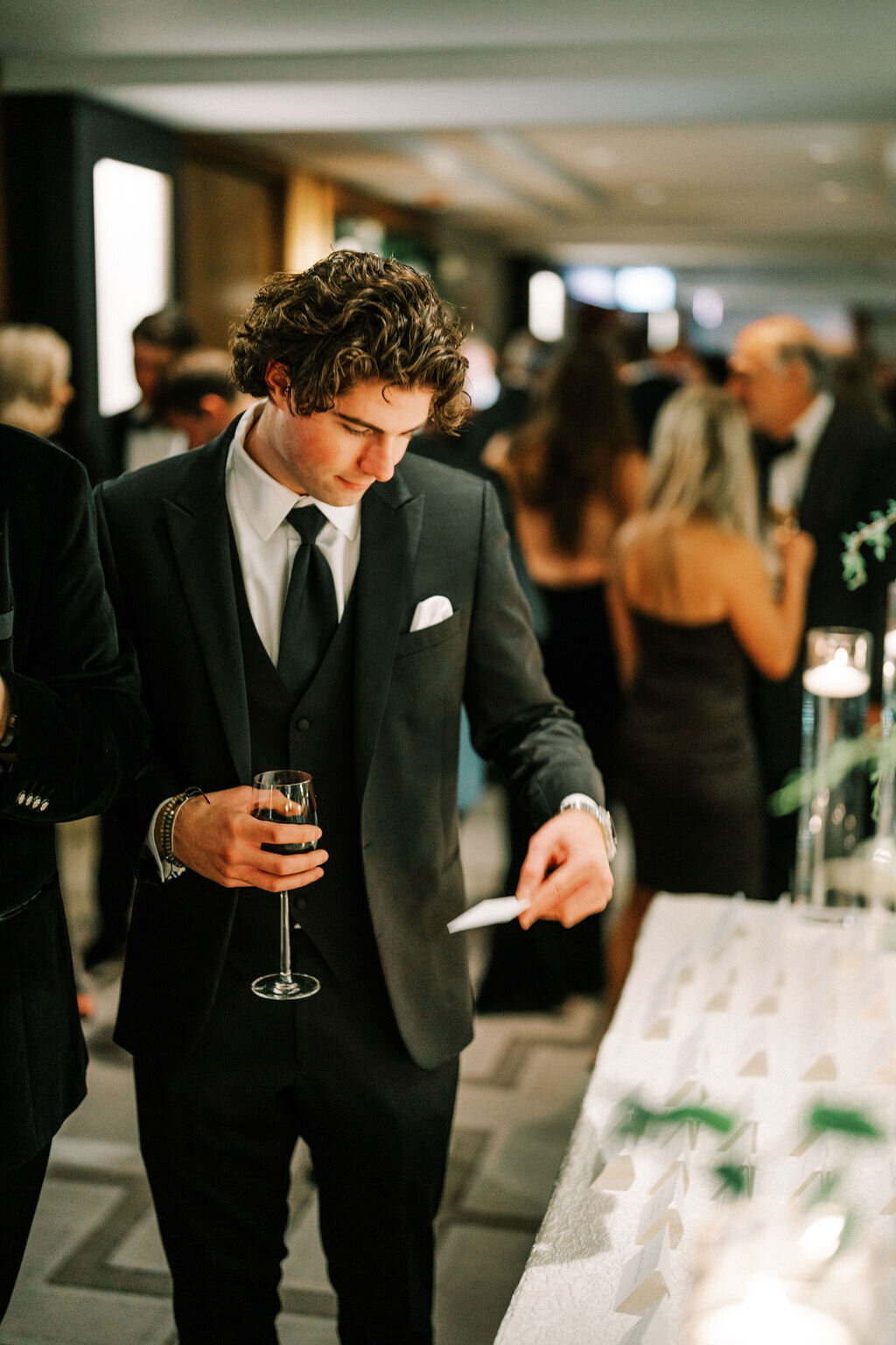 A picture of a guest looking at a place card. 