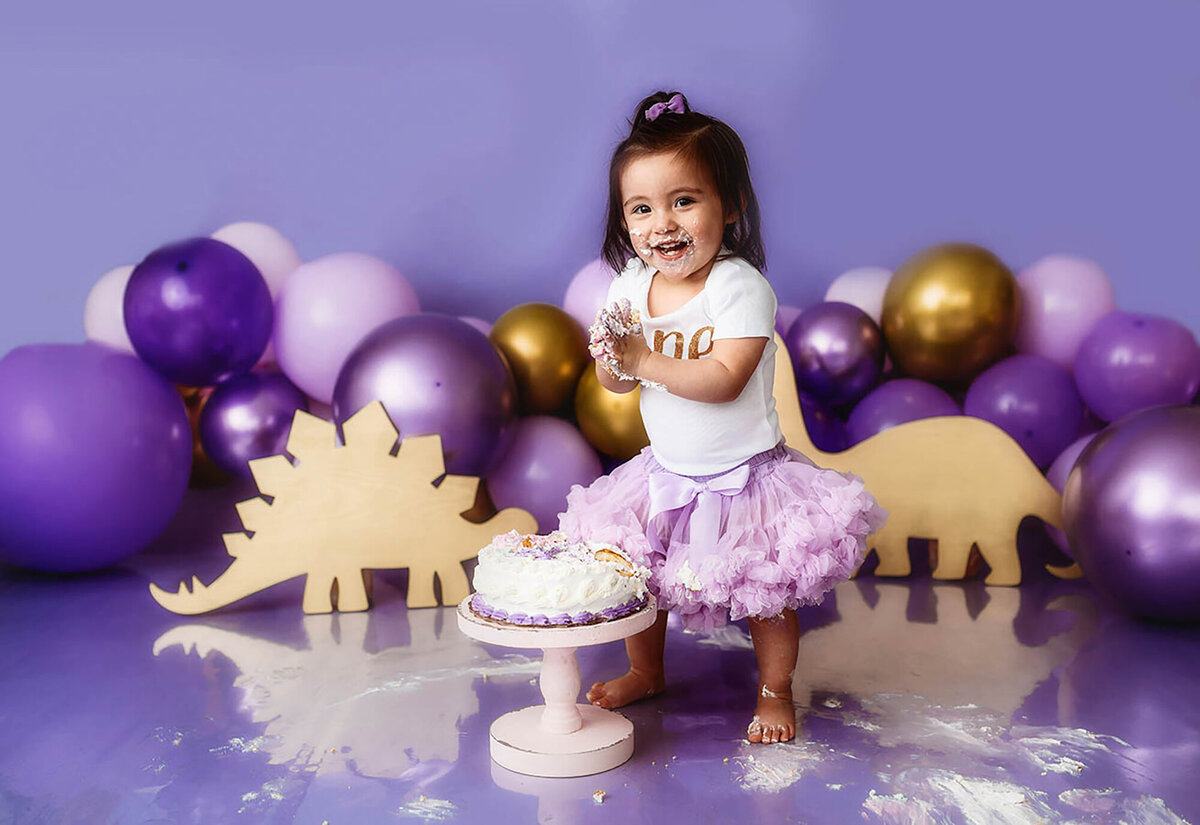 Baby girl peers into the camera during her Cake Smash Birthday Photoshoot in Asheville, NC.