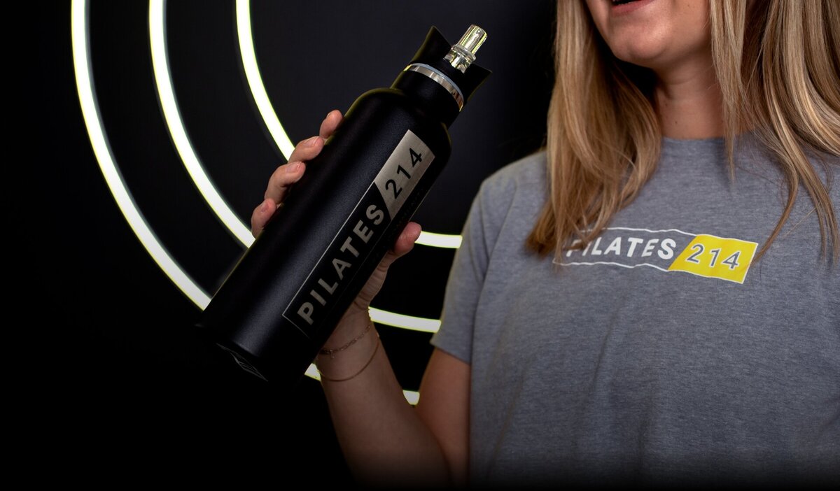 Close-up image of Pilates214 branded shirt and waterbottle.